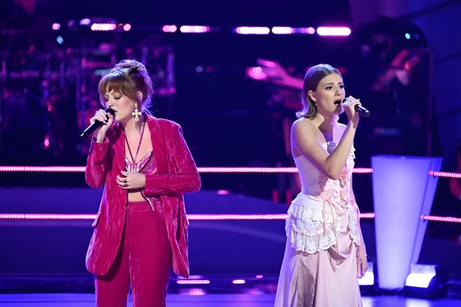 A candid portrait of Simone Marijic (right) and Iris Herrera (left) performing together on the stage of the TV show The Voice.