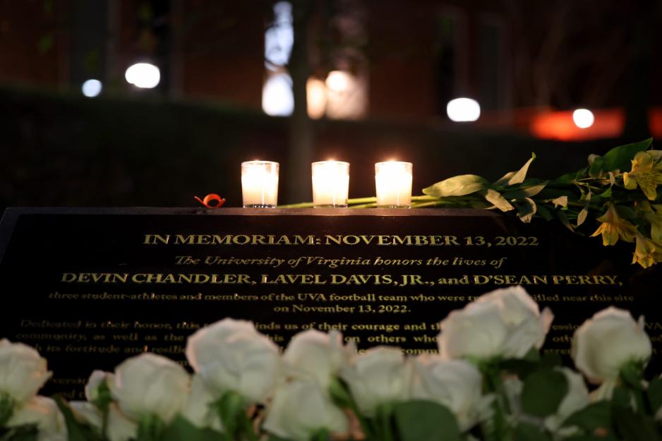 Close up of white roses and csndles by the memorial plaque for Devin Chandler, D’Sean Perry and Lavel Davis Jr.