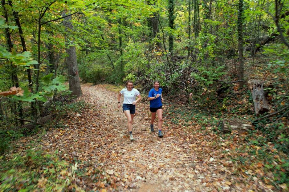 Emily Carder and Sophia Gibby running together on a wooded trail