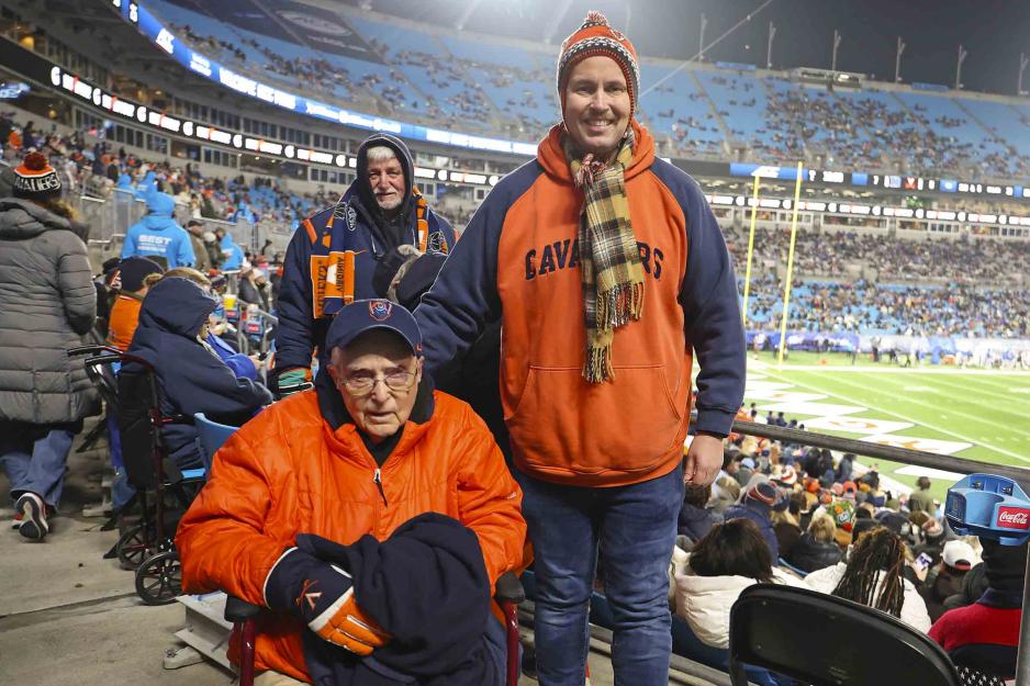 Portrait of William Patterson, a 96-year-old UVA fan, takes in the Cavaliers’ ACC Football Championship Game against Duke alongside his grandson, Jeffrey Witt and in the background is George Jones, Witt’s cousin.
