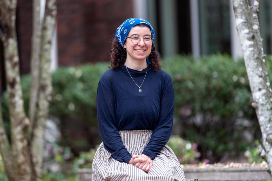 University of Virginia student Alizé Dreyer, in a long-sleeved blue shirt and headscarf, sits with her hands folded in her lap and smiles