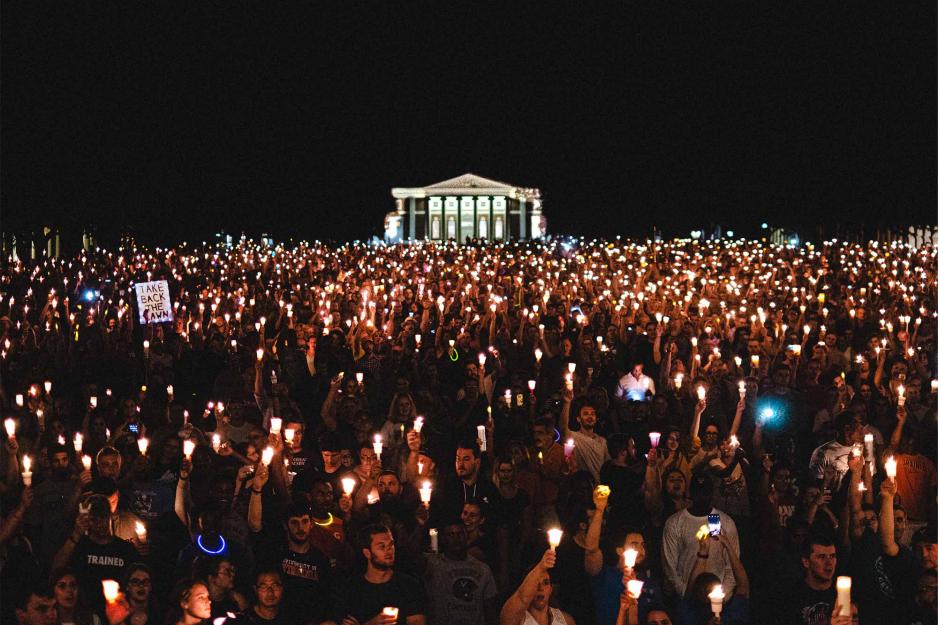 Students gather on the Lawn at night holding electric candles.