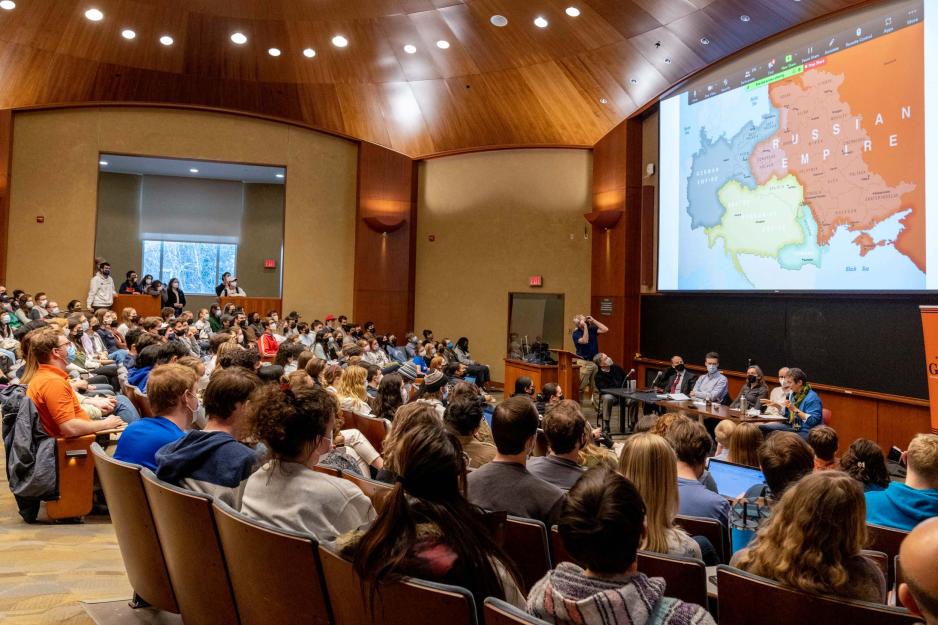 Auditorium full of people listening to a panel discussion about Russia invading Ukraine