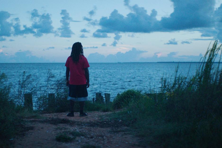 Person standing on a cliff over looking the ocean