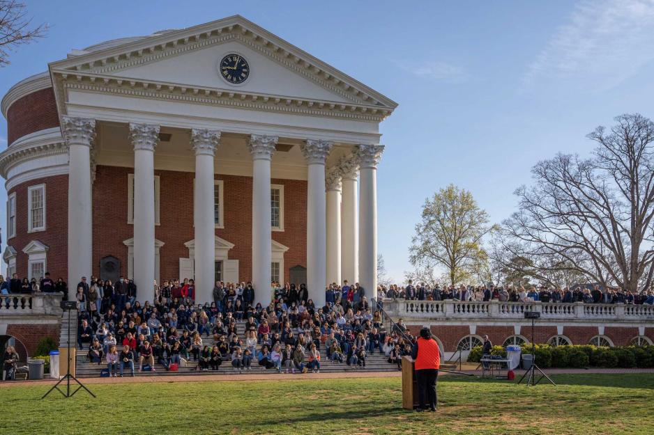 Dozens of students sit on the steps of the UVA Rotunda, as Robyn Hadley addresses them from a podium on the Lawn
