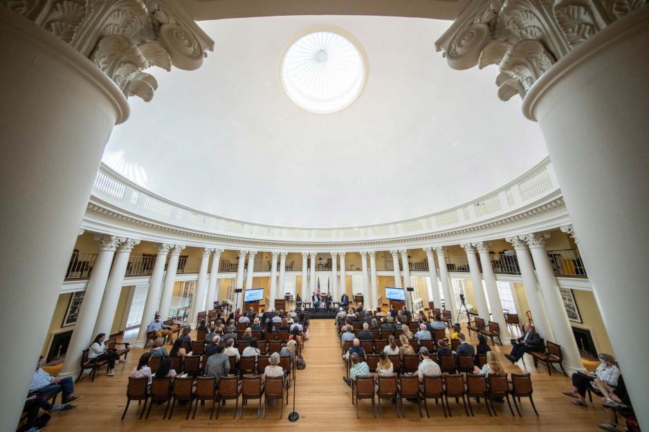 A view through two columns of a full audience in the UVA Rotunda Dome Room.