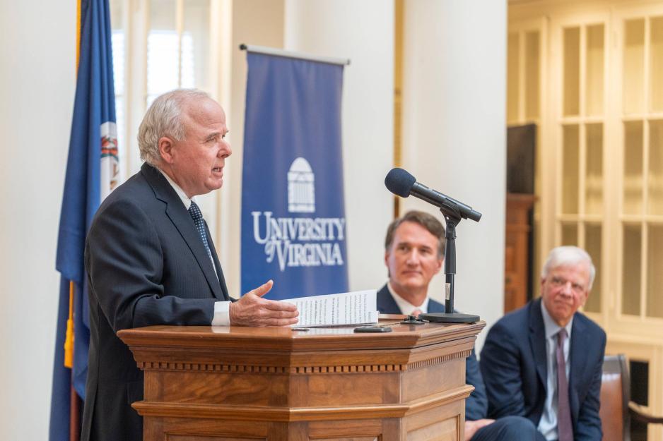 Paul Manning talking at podium, in the Rotunda, Gov. Glenn Youngkin and Dr. K. Craig Kent listening in