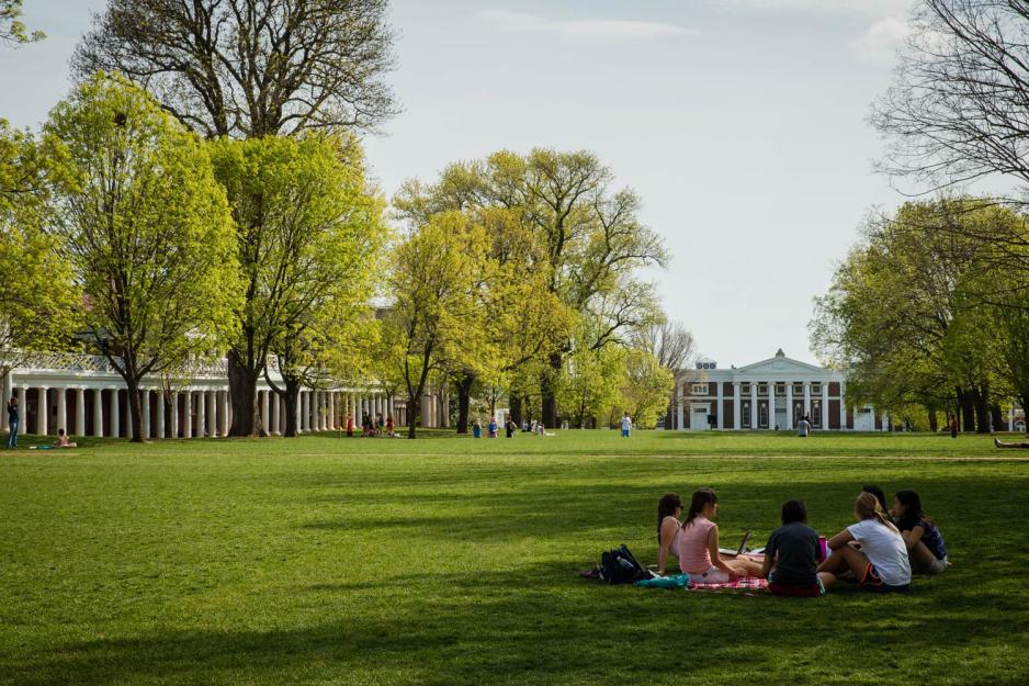 UVA students sit in a circle under a shade tree during a spring afternoon on the Lawn
