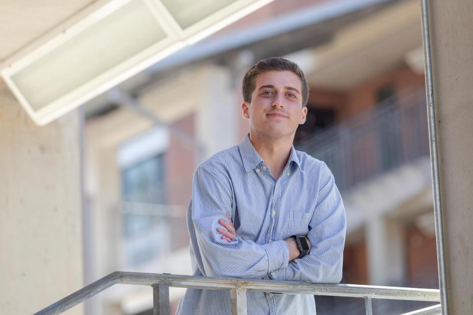 Jack MacLeod leans over a steel railing, smiles at the camera