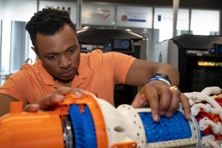 Joshua Franklin manipulates parts of a mechanical model