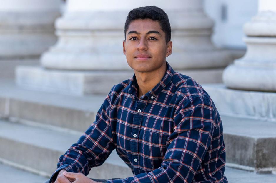 Portrait of Luis Jerez seated on the steps of the UVA Rotunda, confidently facing the camera