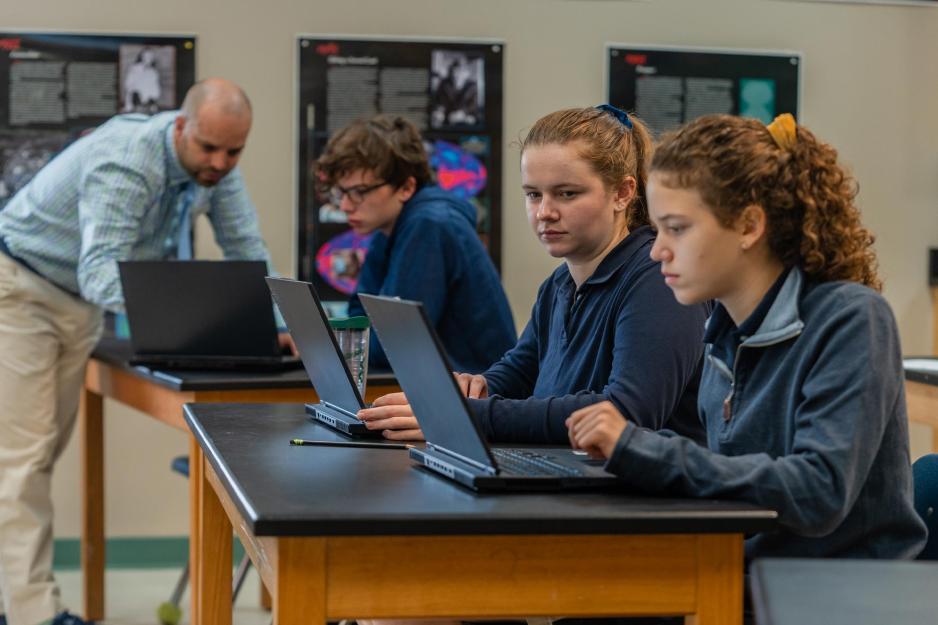 Matt Daolios working with students at a table