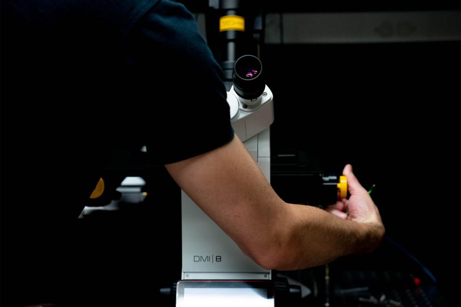 A person makes adjustments to a piece of research equipment