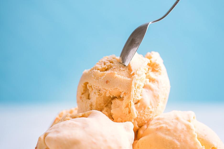 Close up of a spoon digging into a small mountain of ice cream