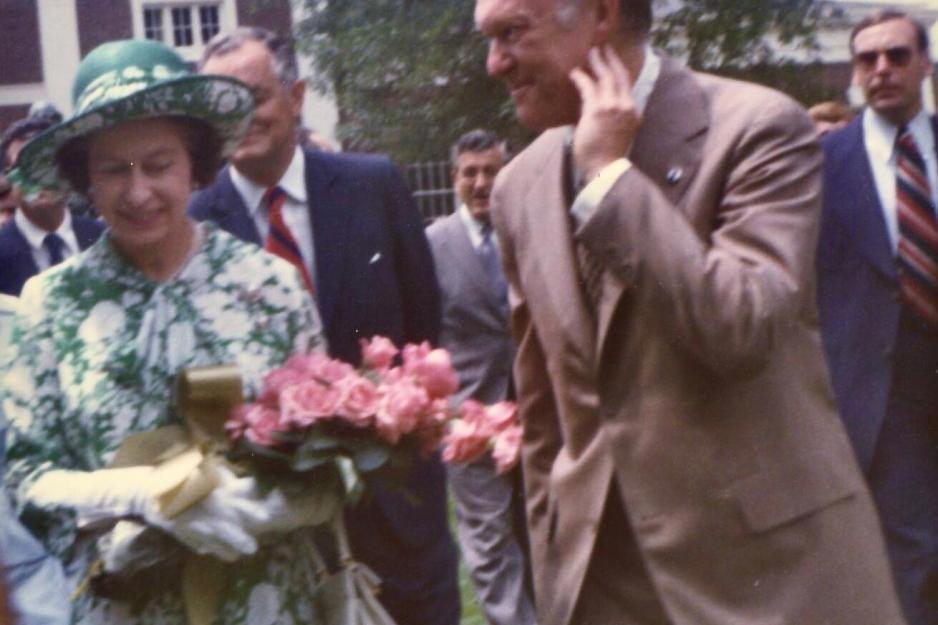 Queen Elizabeth walking on a street surrounded by people