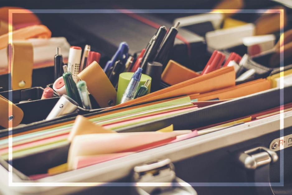 Various pens, markers, and pencils in organizers with other office supplies