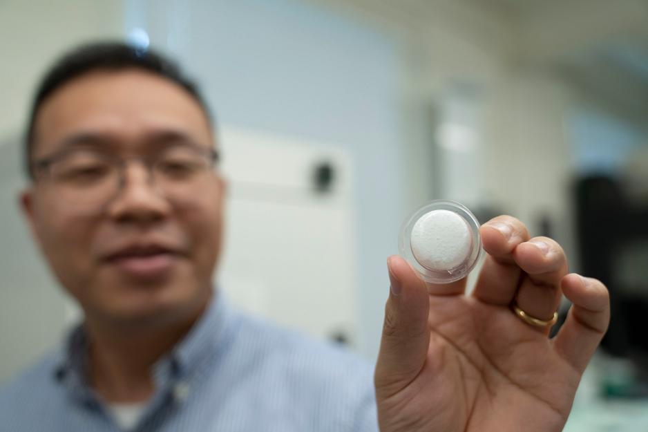 Portrait of Baoxing Xu with the focus on the liquid nanofoam system sample he is holding