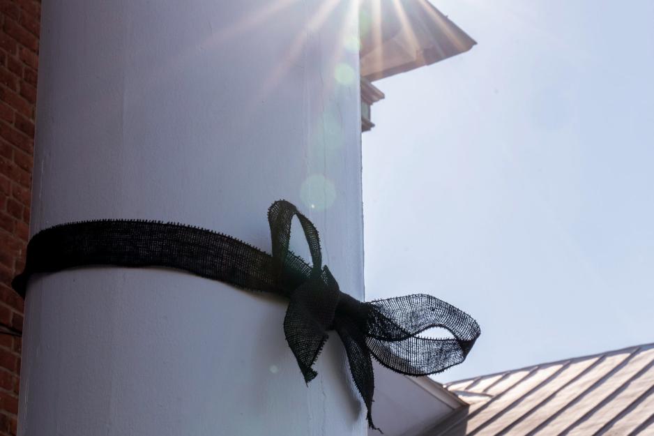 Black ribbon bow tied around white pillar