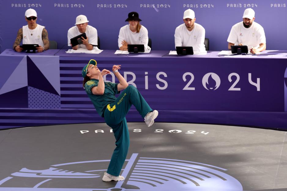 Candid photo of Australian breakdancer Rachael Gunn performing in front of panels.
