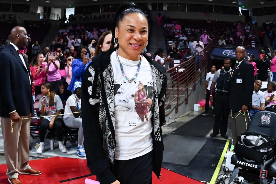 Dawn Staley walks through a crowd sporting meaningful clothing an accessory items.