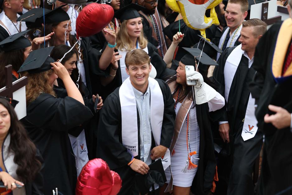 A group of grads gather and celebrate before walking the lawn