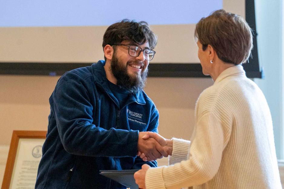 Rene Teran Vazquez accepting his diploma and shaking hands with Colette Sheehy