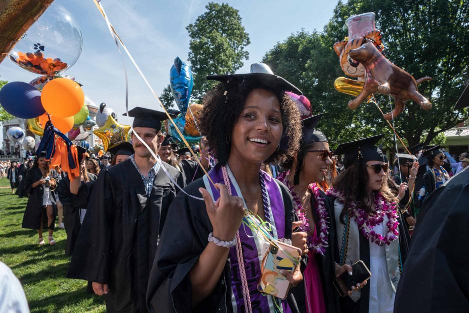 Grad smiles in the direction of the camera, holding a balloon