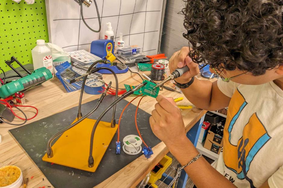 A student hard at work on the wiring of a robot