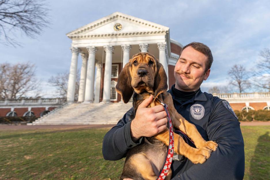 Portrait of Maggie the bloodhound and officer Logan Moore on the Lawn