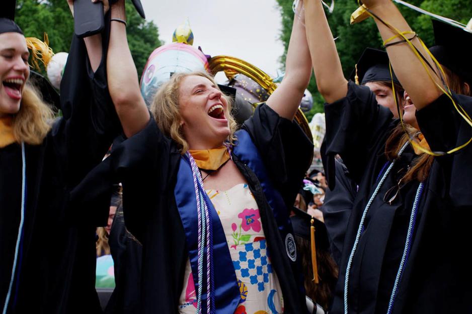 Graduates put their hands up in celebration