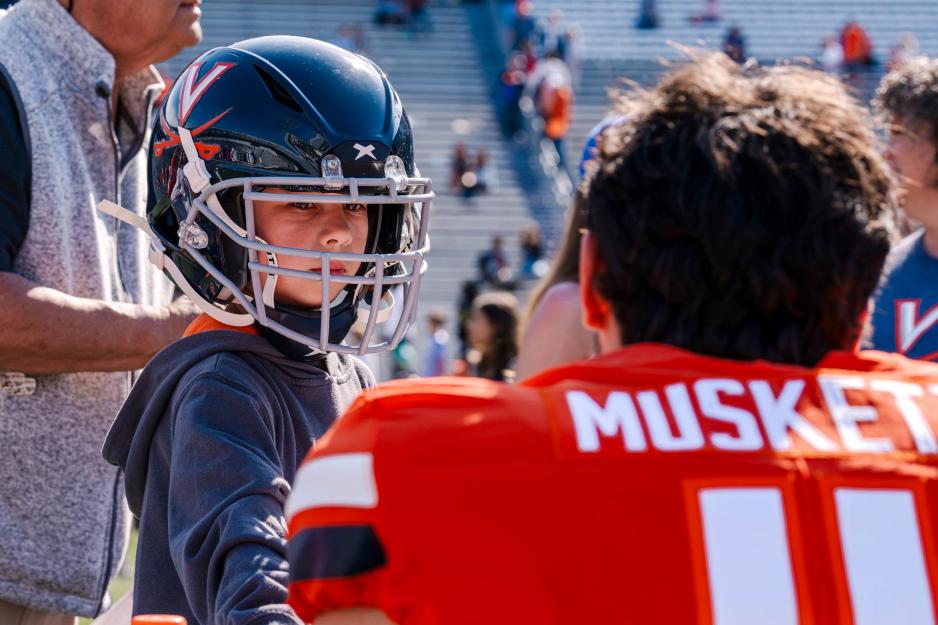 A child wears UVA football player Musket's helmet 