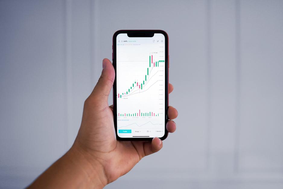 A hand holds an iPhone with a financial app open