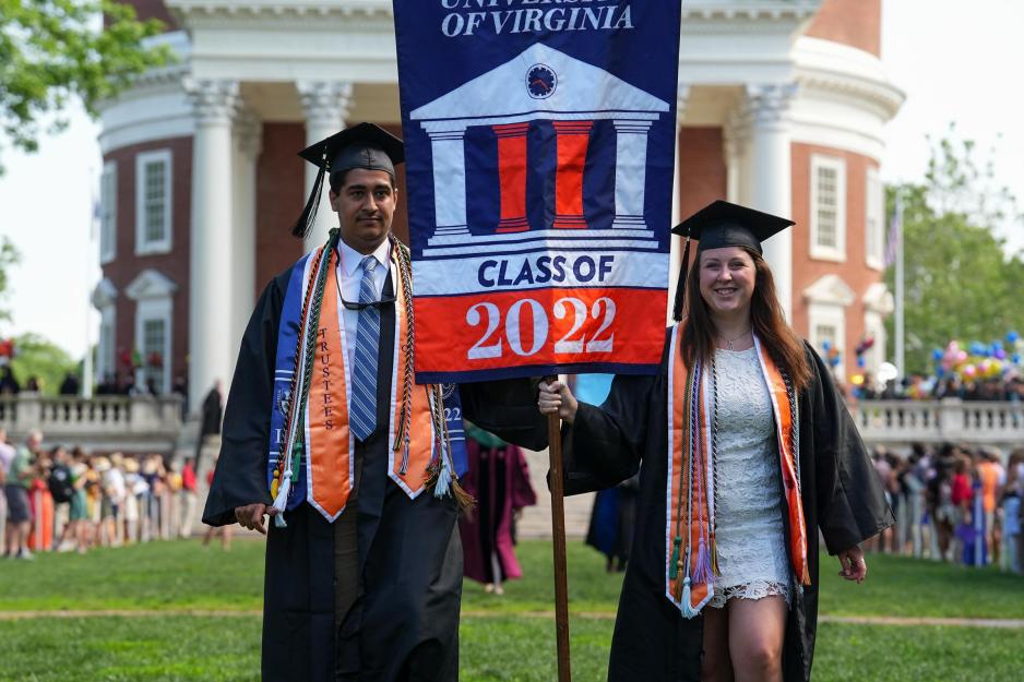Two graduating students carry the Class of 2022 flag