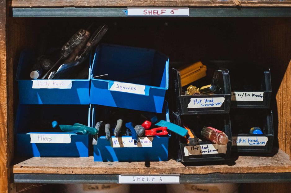 Small, labeled storage bins filled with hand tools