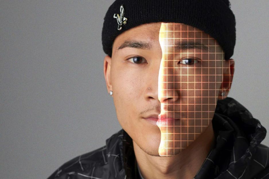 Man staring at camera.  Half of his face has a grid on it for AI rendering.