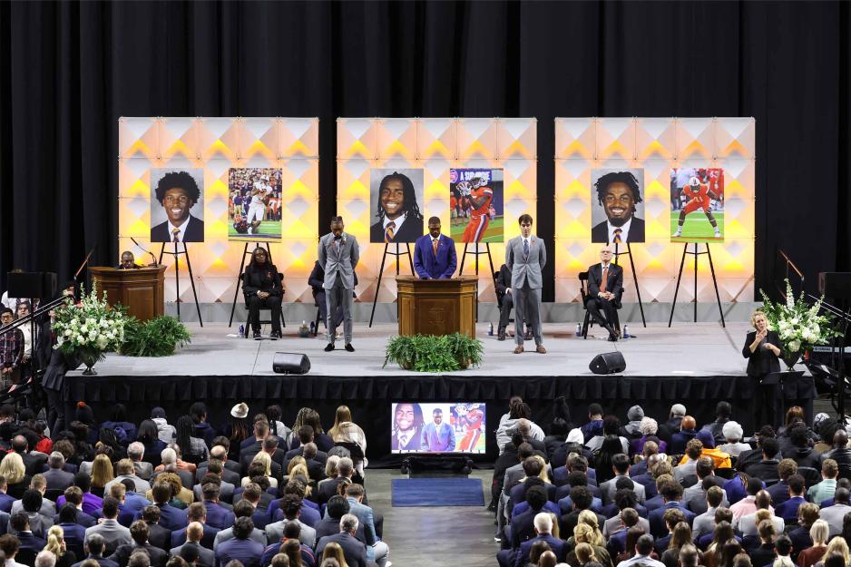 UVA football teammates stand on stage at memorial for Slain players
