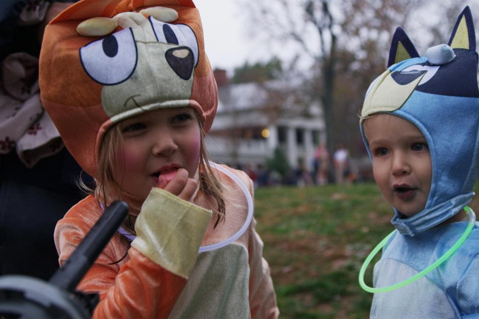Two little kids in costumes standing on the Lawn