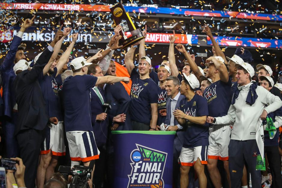 UVA mens basketball team lifts their trophy high in the air with confetti falling down