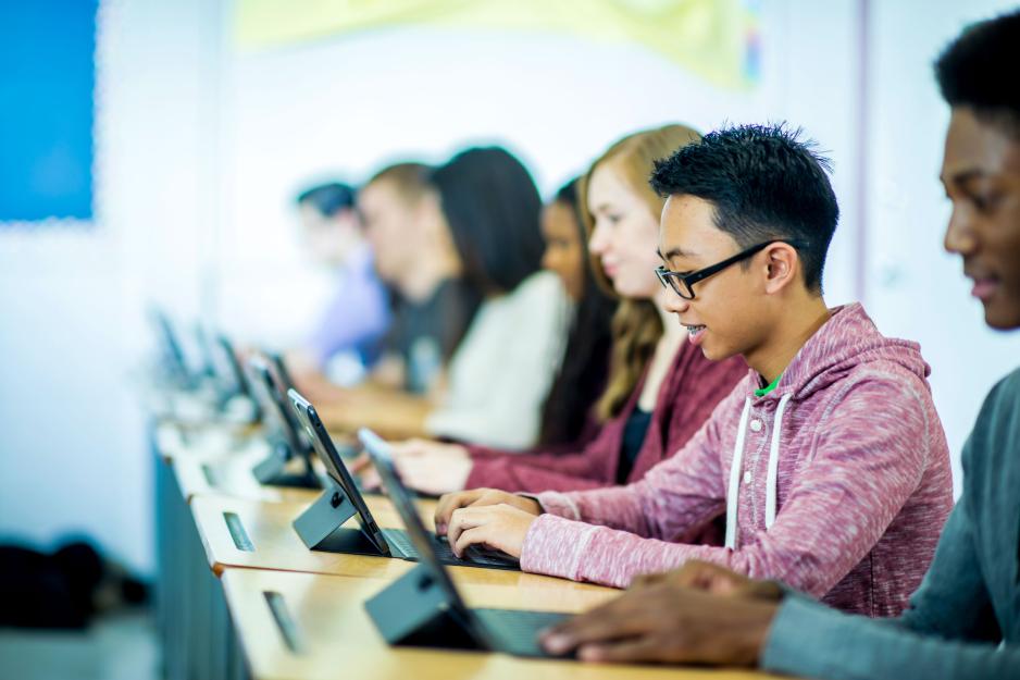 Students working on laptops at desks
