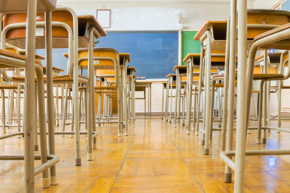 Empty Classroom chairs and desks and empty green blackboard