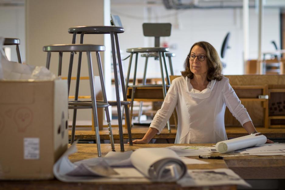 Elizabeth K. Meyer stands at a table with rolled up plans