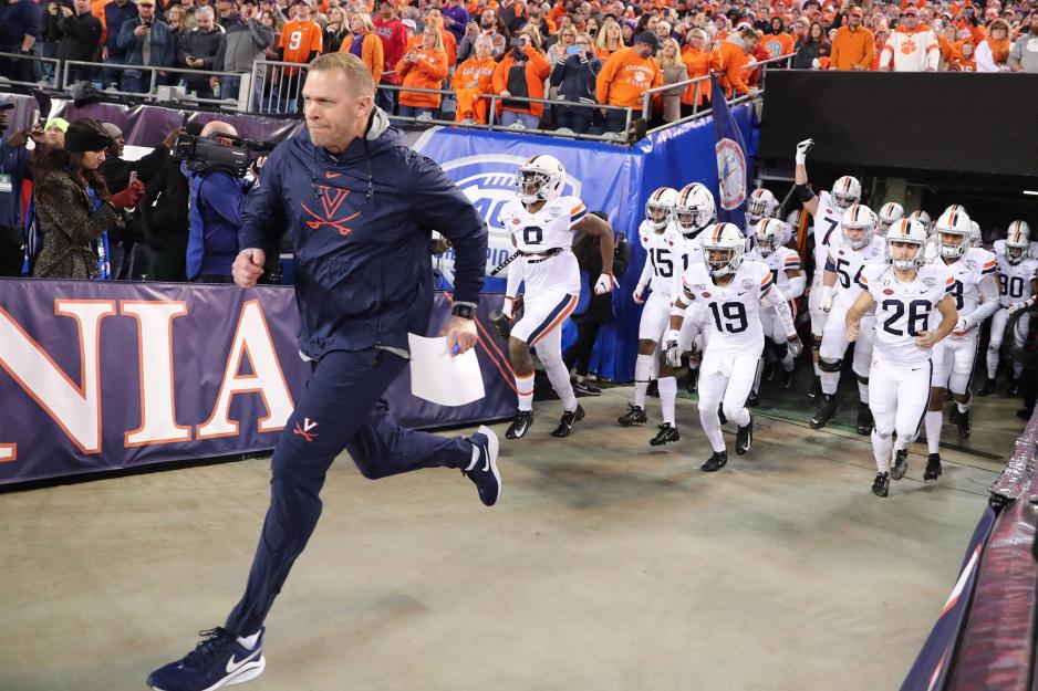 Coach Bronco Mendenhall and the UVA Cavaliers running out of the locker room unto the field