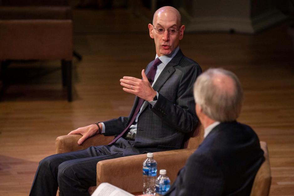Adam Silver speaking to another man on stage