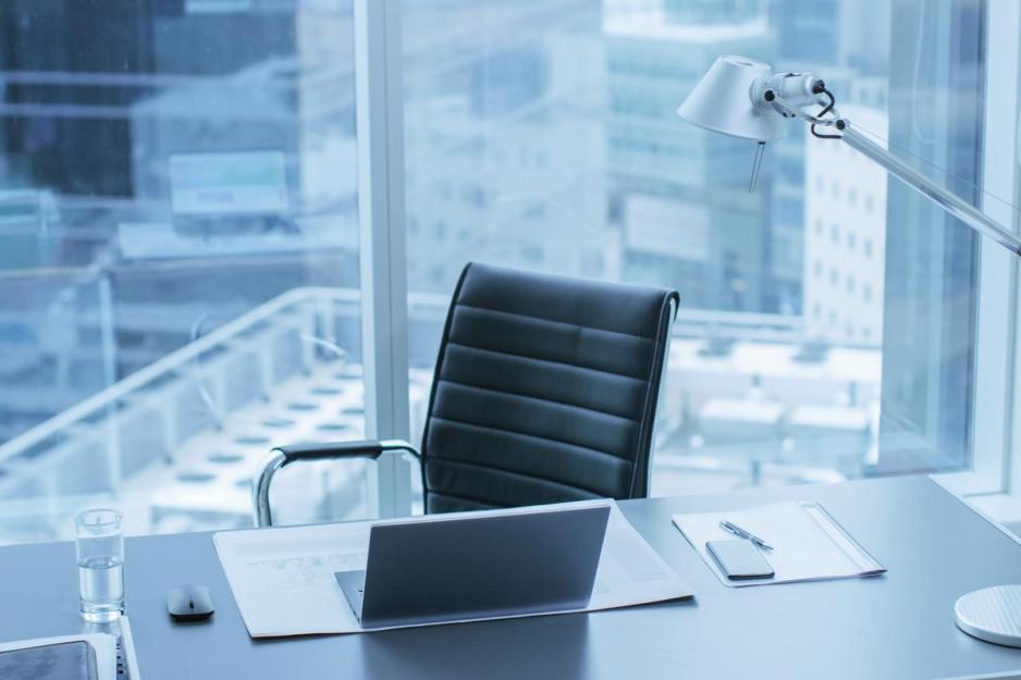 Empty chair with a laptop on the desk open