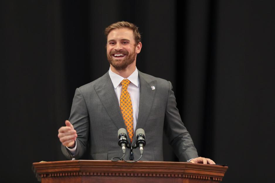 Chris Long, standing at a podium giving a speech 