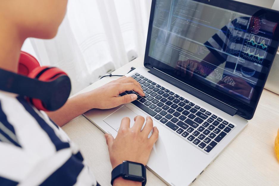 Person working on a laptop sitting at a table