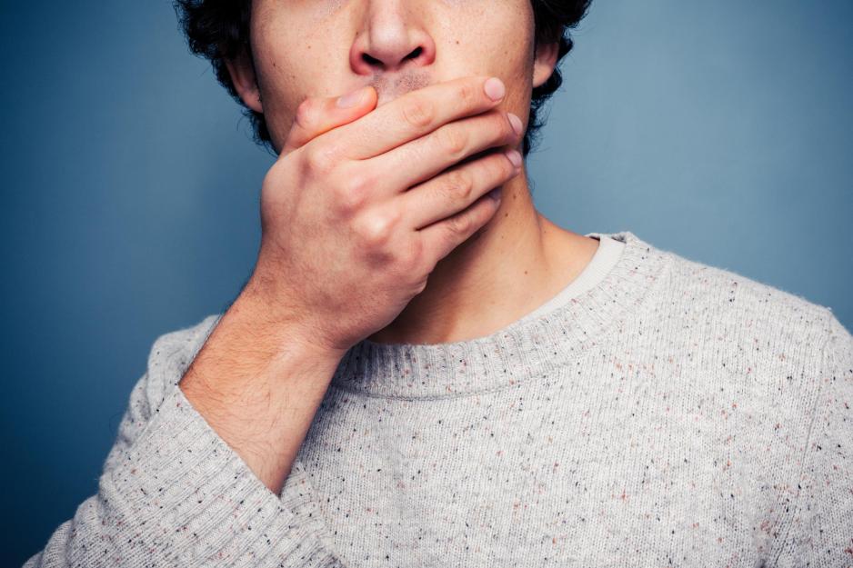 Man holding their hand over their mouth