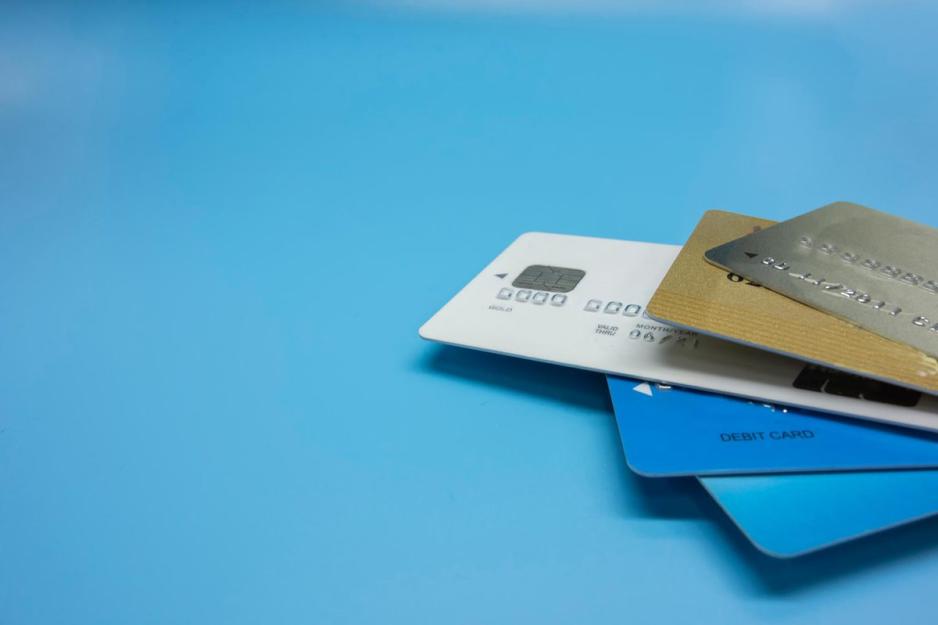 five credit cards stacked together on a sky blue background
