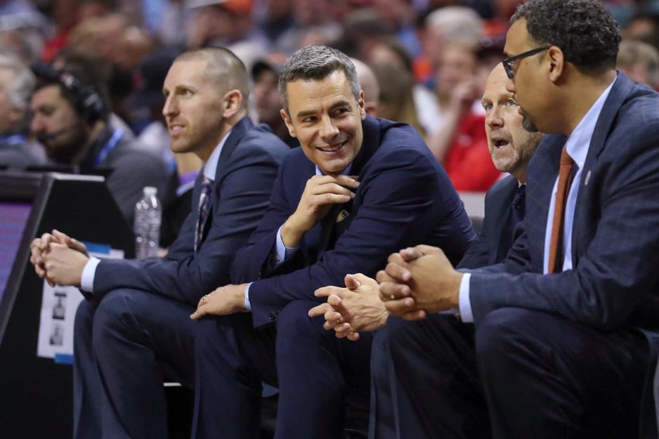 Tony Bennet talking to coaches on the side of the basketball court