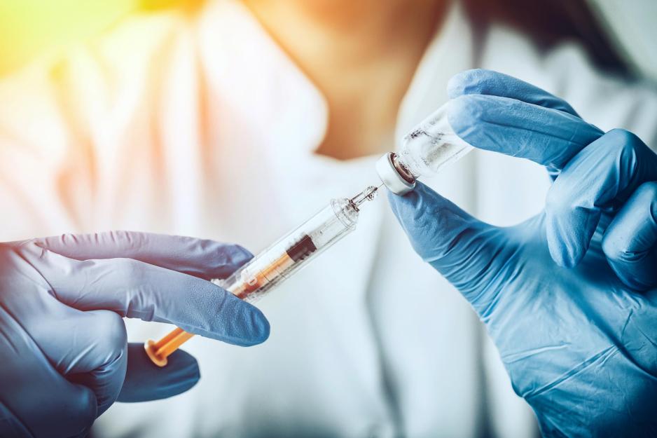 Healthcare professional drawing up a vaccine into a syringe 
